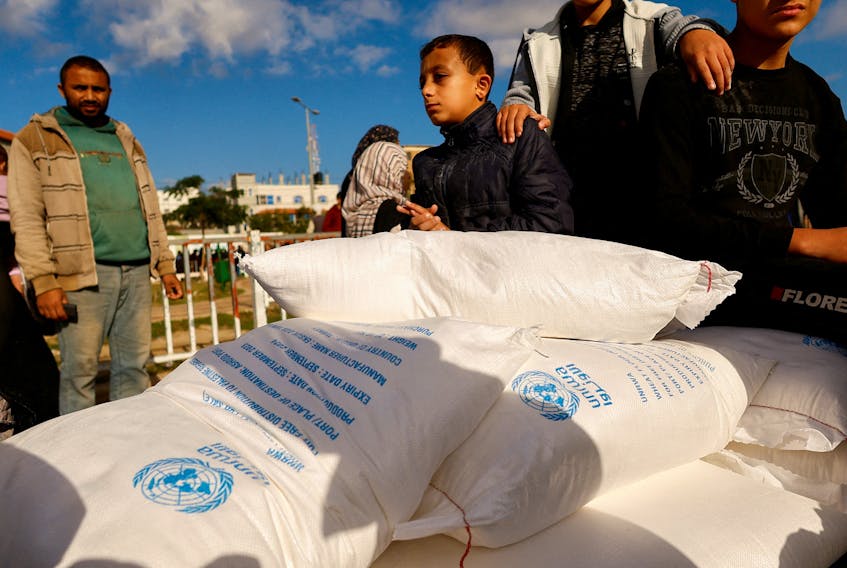 Palestinians receive flour bags distributed by UNRWA in Rafah, in the southern Gaza Strip November 21, 2023.