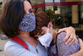 A woman wearing a face mask hugs a demonstrator during a protest against violence towards women, after the femicide of Ursula Bahillo, in Buenos Aires, Argentina, February 17, 2021.