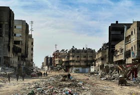 People walk near damaged houses at Zeitoun neighborhood after Israeli forces withdrew from the area, in Gaza City March 1, 2024.