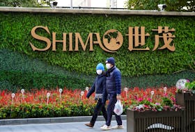 People walk past the logo of property developer Shimao Group near Shimao Tower in Shanghai, China January 13, 2022.