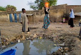 A woman carries a container filled of water in a poor neighbourhood in N'djamena, Chad April 25, 2021.