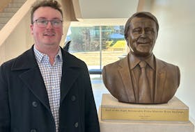 Gerry Byrne Jr. of Corner Brook, who will graduate from St. Francis Xavier University with a business degree this spring, poses by a bust of former prime minister Brian Mulroney at the Brian Mulroney Institute of Government on the campus. - Contributed