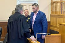 Craig Pope speaks with his lawyer, Mark Gruchy, before sheriffs escort him from a St. John's courtroom Thursday, Feb 29 to begin his sentence for second-degree murder.