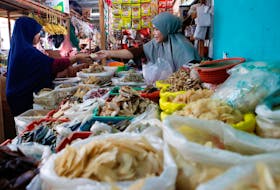A vendor serves a customer at a traditional market in Jakarta, Indonesia, January 2, 2023.