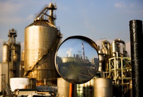 A factory is reflected in a traffic mirror at the Keihin industrial zone in Kawasaki, south of Tokyo, November 30, 2015.