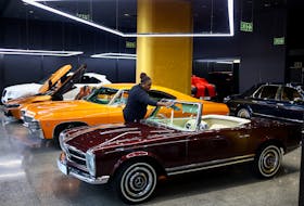 A worker cleans a 1964 Mercedes-Benz 230SL car, displayed at a Thobela Cars showroom in Sandton, South Africa, January 24, 2024.