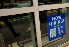 An employee hiring sign with a QR code is seen in a window of a business in Arlington, Virginia, U.S., April 7, 2023.