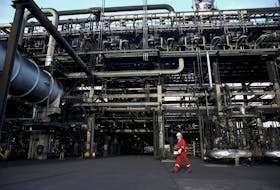 An oilfield worker walks next to pipelines at PDVSA's Jose Antonio Anzoategui industrial complex in the state of Anzoategui April 15, 2015.