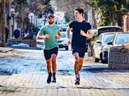 Ethan Bensadoun, left, and Elijah Djanogly run along Duluth Ave. in shorts and T-shirts on an unseasonably warm day in Montreal Tuesday Feb. 27, 2024.
