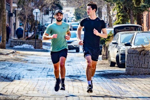 Ethan Bensadoun, left, and Elijah Djanogly run along Duluth Ave. in shorts and T-shirts on an unseasonably warm day in Montreal Tuesday Feb. 27, 2024.