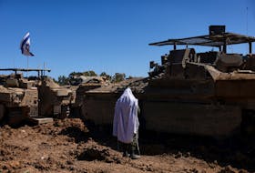 An Israeli soldier stands near military vehicles near the Israel-Gaza border, amid the ongoing conflict between Israel and the Palestinian group Hamas, in Israel, March 11. REUTERS/Ronen Zvulun