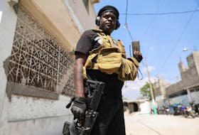 Former police officer Jimmy "Barbecue" Cherizier, and leader of an alliance of armed groups, speaks to a news outlet on a mobile phone during a news conference, in Port-au-Prince, Haiti, March 11, 2024. REUTERS/Ralph Tedy Erol