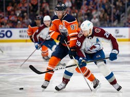 Connor McDavid (97) of the Edmonton Oilers battles against Nathan MacKinnon (29) of the Colorado Avalanche at Rogers Place on April 9, 2022, in Edmonton, Canada.