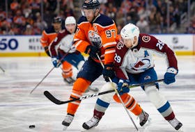 Connor McDavid (97) of the Edmonton Oilers battles against Nathan MacKinnon (29) of the Colorado Avalanche at Rogers Place on April 9, 2022, in Edmonton, Canada.