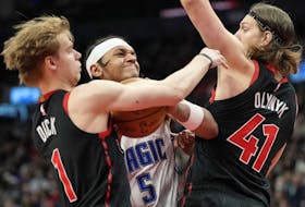 Magic forward Paolo Banchero (centre) tries to drive between Raptors guard Gradey Dick (left) and teammate Kelly Olynyk (right) during second half NBA action in Toronto, Friday, March 15, 2024.