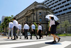 People walk past the Bank of Japan building in Tokyo, Japan June 16, 2017.