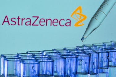 Test tubes are seen in front of a displayed AstraZeneca logo in this illustration taken, May 21, 2021.