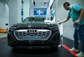 A worker cleans an Audi Q8 55 e-tron quattro EV car, on the day of the annual news conference of the Volkswagen Group at DRIVE.Volkswagen Group Forum, in Berlin, Germany March 14, 2023.