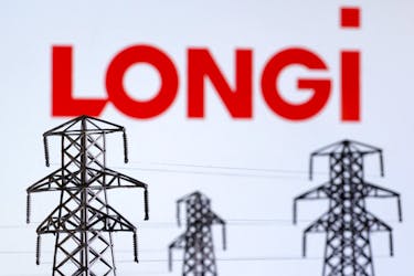 Electric power transmission pylon miniatures and LONGi Green Energy Technology logo are seen in this illustration taken, December 9, 2022.