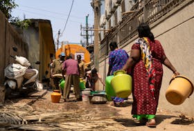 Residents arrive to get their containers filled with drinking water from a water tanker supplied by Bruhat Bengaluru Mahanagara Palike(BBMP) in a neighbourhood that is facing severe water scarcity, in the south of Bengaluru, India, March 11, 2024.