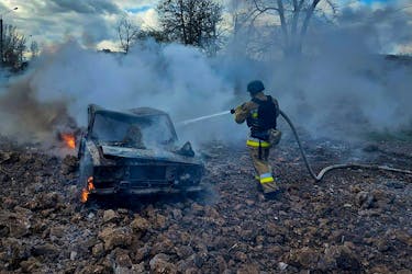 A firefighter extinguishes fire in a car destroyed during a Russian missile strike, amid Russia's attack on Ukraine, in Mykolaiv, Ukraine March 17, 2024. Press service of the State Emergency Service of Ukraine in Mykolaiv region/Handout via