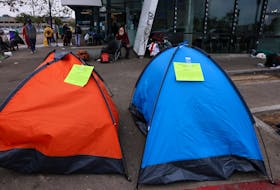Eviction notices from the city of San Diego are attached to homeless tents on a city sidewalk, in San Diego, California, U.S., February 26, 2024. 