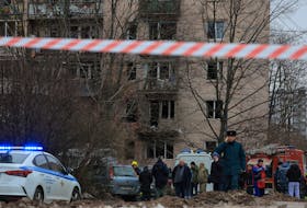 Members of emergency services and investigators gather near a damaged multi-storey residential building following an alleged drone attack in Saint Petersburg, Russia, March 2, 2024.