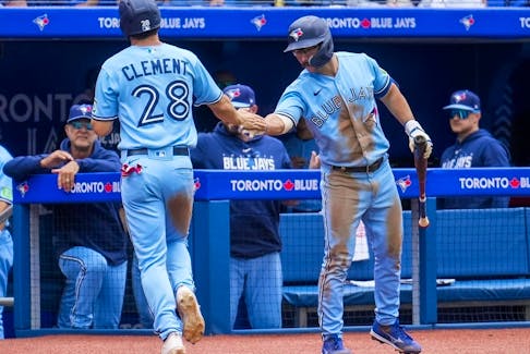 The Toronto Blue Jays' Ernie Clement (28) celebrates with teammate Davis Schneider (36) after scoring a run on a sacrifice fly against the Washington Nationals during fourth-inning MLB interleague baseball action in Toronto on Wednesday, Aug. 30, 2023. Both players are starting the 2024 season with the Blue Jays, the team announced.