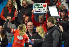 Canada skip Rachel Homan, left, acknowledges the fans as one raises a sign in support after Canada captured the World Women’s Curling Championship at Centre 200 in Sydney on Sunday. JEREMY FRASER/CAPE BRETON POST