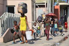 People walk towards a shelter with their belongings fleeing from violence around their homes, in Port-au-Prince, Haiti March 9.  Ralph Tedy Erol • Reuters