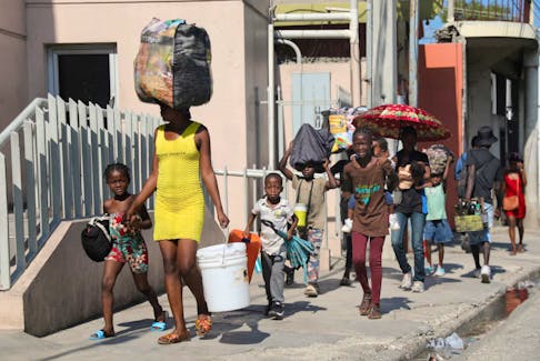 People walk towards a shelter with their belongings fleeing from violence around their homes, in Port-au-Prince, Haiti March 9.  Ralph Tedy Erol • Reuters