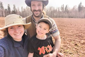 Dakota Oliver, left, her partner James Strongman, and their son, Tucker strongman, stand in their field. In 2023, the Alberton couple started a farm, Strongman's Hand-Picked Produce, and are now paying it forward through creating a Facebook group dedicated to sharing fresh vegetables. – Contributed