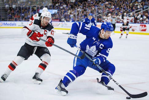 Toronto Maple Leafs centre John Tavares (91) skates the puck by New Jersey Devils centre Nico Hischier.
