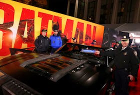 NYPD officers pose next to a "Batmobile" during the New York Premiere of "The Batman", in New York City, U.S. March 1, 2022.