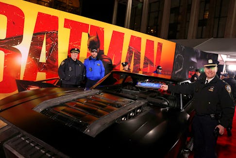 NYPD officers pose next to a "Batmobile" during the New York Premiere of "The Batman", in New York City, U.S. March 1, 2022.