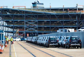 Cars readied for export are parked next to a vehicle storage facility on the dockside at the ABP port in Southampton, Britain August 16, 2017. Picture taken August 16, 2017. 
