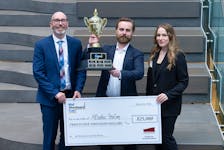 Dante Enewold, middle, accepts a $25,000 cheque for winning the recent Mel Woodward Cup startup pitch competition in St. John’s from Ed Martin, left, director of the Memorial Centre for Entrepreneurship, and Gillian Woodward. – Contributed