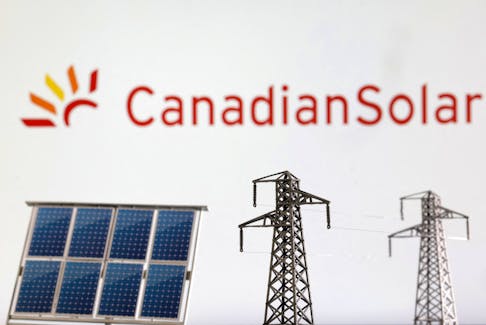 Miniatures of solar panel and electric pole are seen in front of Canadian Solar logo in this illustration taken January 17, 2023.