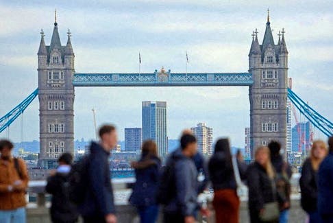 People walk over London Bridge with at a view of Tower Bridge in the City of London financial district, in London, Britain, October 25, 2023.