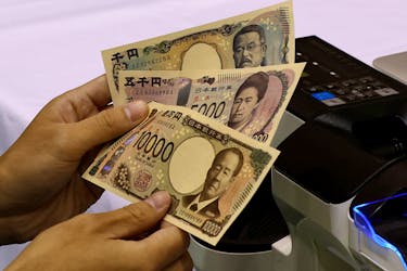 A worker holds samples of new Japanese yen banknotes at a factory of the National Printing Bureau producing Bank of Japan notes at a media event about the new notes scheduled to be introduced in 2024, in Tokyo, Japan, November 21, 2022.