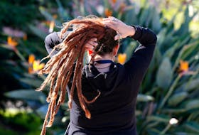 A woman arranges her dreadlocked hair in a public square in Valparaiso, Chile October 11, 2017.