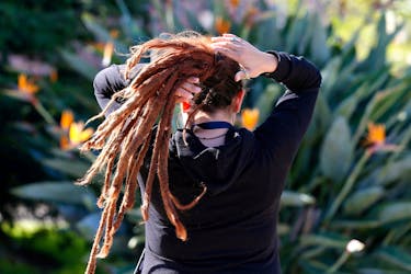 A woman arranges her dreadlocked hair in a public square in Valparaiso, Chile October 11, 2017.