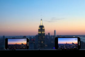 Smartphones are used to record the skyline at sunset in Manhattan, in New York City, New York U.S., February 11, 2022.