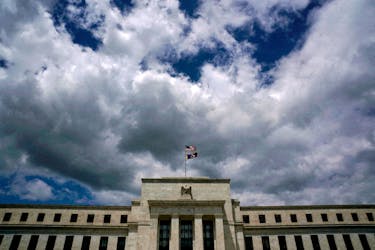 Flags fly over the Federal Reserve building on a windy day in Washington, U.S., May 26, 2017.