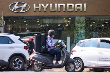A man rides a scooter past a Hyundai automobile showroom in Mumbai, India, February 9, 2022.