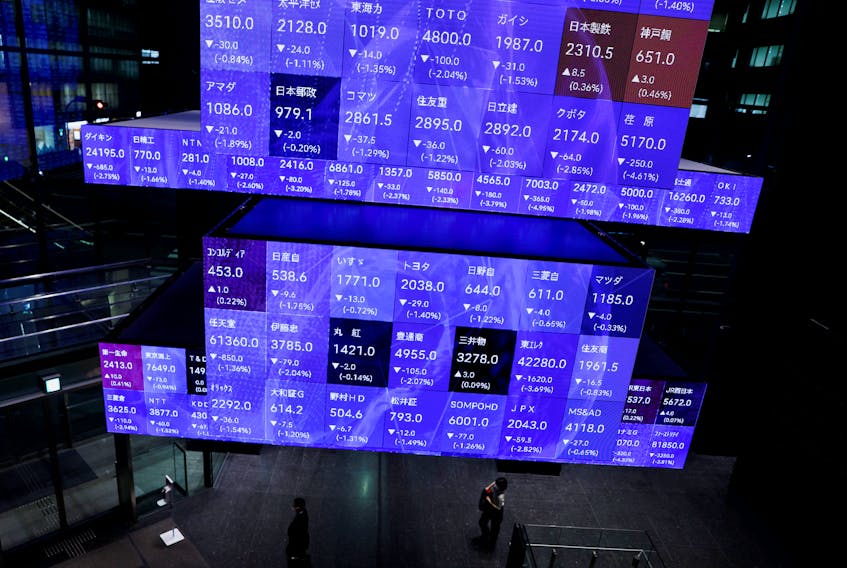 Visitors walk past Japan's Nikkei stock prices quotation board inside a conference hall in Tokyo, Japan September 14, 2022.