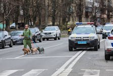 A local resident walks with his dogs near the site of a Russian missile strike, amid Russia's attack on Ukraine, in Kyiv, Ukraine March 25, 2024.