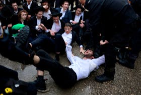 A protester is taken away as Ultra-Orthodox Jewish men protest against attempts to change government policy that grants ultra-Orthodox Jews exemptions from military conscription, in Jerusalem, March 18, 2024.