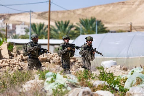 Members of the Israeli army check around the scene of a shooting incident, near Jericho in the Israeli-occupied West Bank, March 28, 2024.