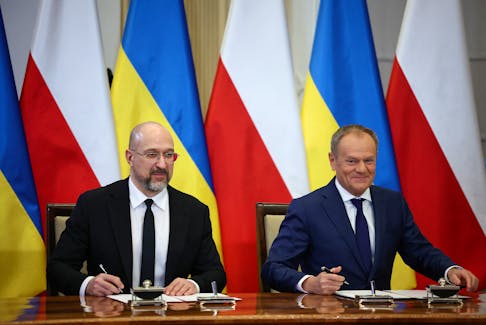 Polish Prime Minister Donald Tusk and Ukrainian Prime Minister Denys Shmyhal look on as they sign documents during a joint press conference in Warsaw, Poland, March 28, 2024.